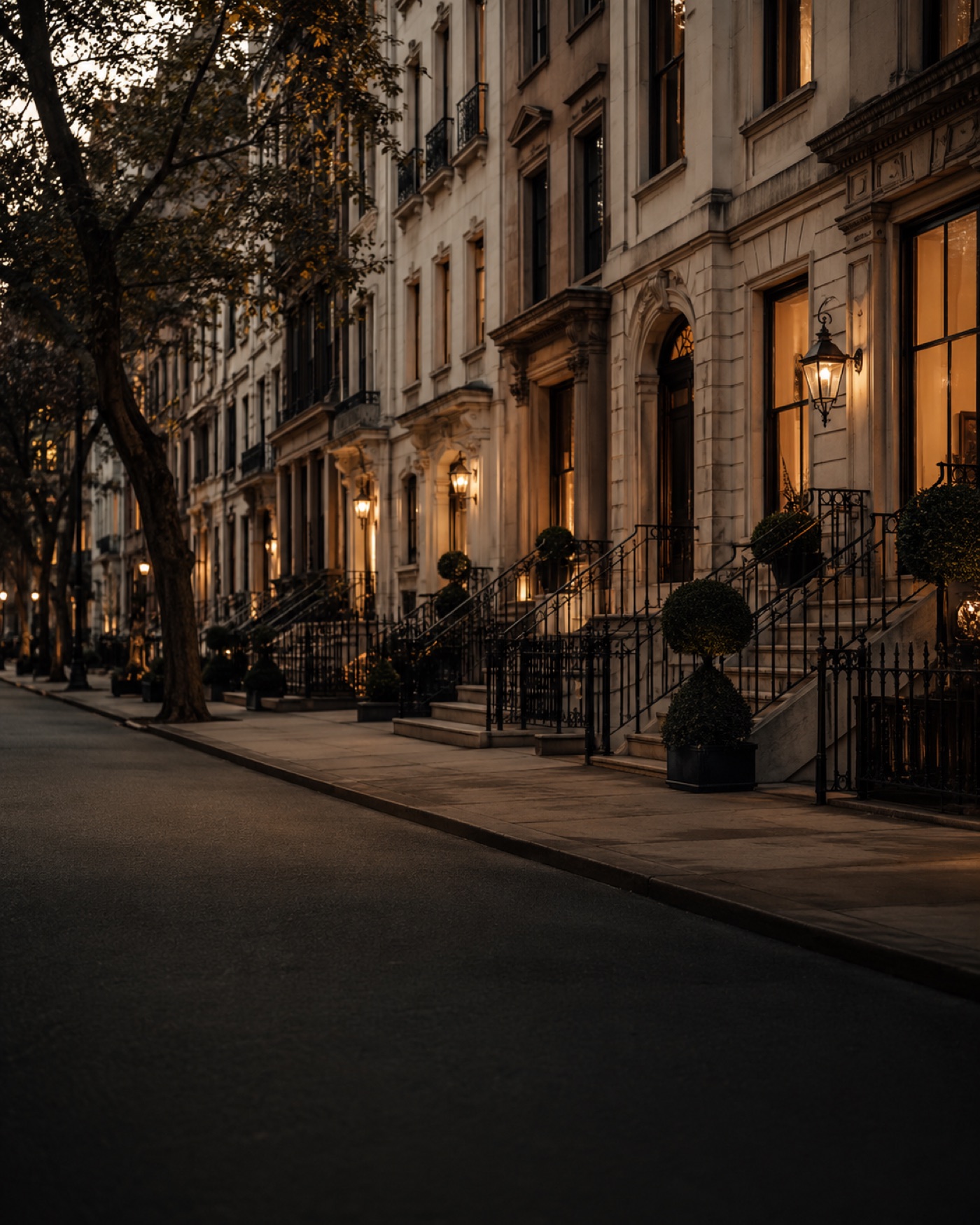 Lamplit brownstone street in New York at dusk